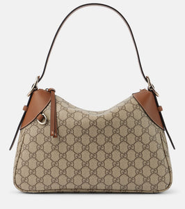 Gucci GG Canvas Medium leather-trimmed shoulder bag. Shop Gucci Shoulder Bags for women now.
