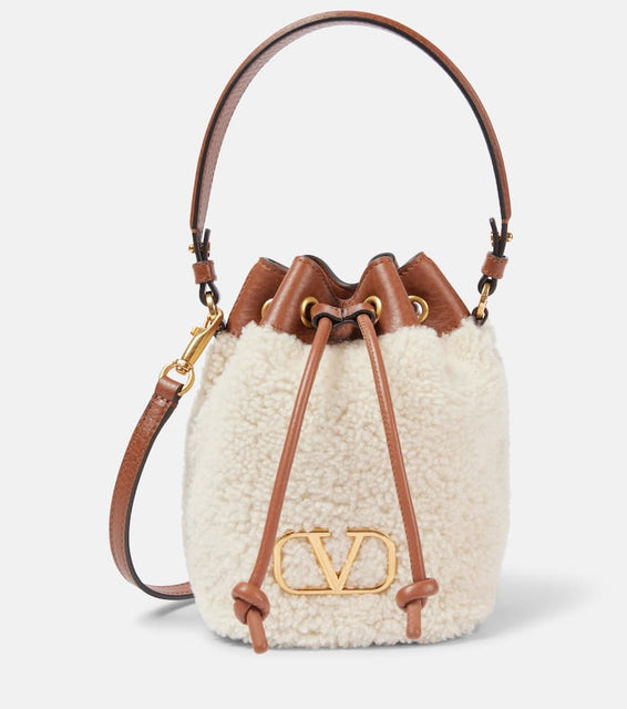 Valentino Garavani VLogo Signature shearling bucket bag. Shop Valentino Garavani Top-Handle Bags for women now.