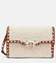 Valentino Garavani Rockstud Small shearling shoulder bag. Shop Valentino Garavani Crossbody Bags for women now.