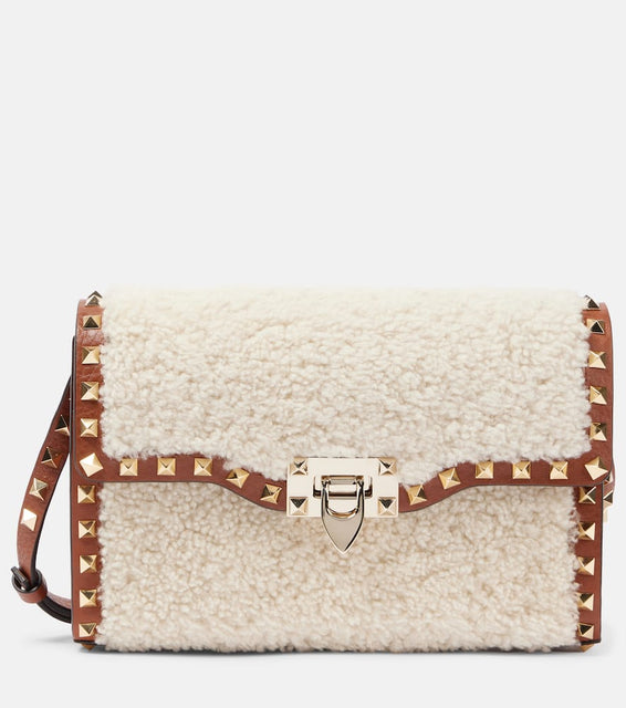 Valentino Garavani Rockstud Small shearling shoulder bag. Shop Valentino Garavani Crossbody Bags for women now.