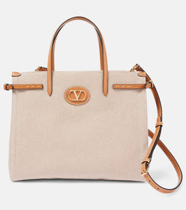 Valentino Garavani VLogo Mini leather-trimmed shoulder bag. Shop Valentino Garavani Tote Bags for women now.