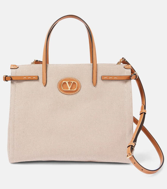 Valentino Garavani VLogo Mini leather-trimmed shoulder bag. Shop Valentino Garavani Tote Bags for women now.